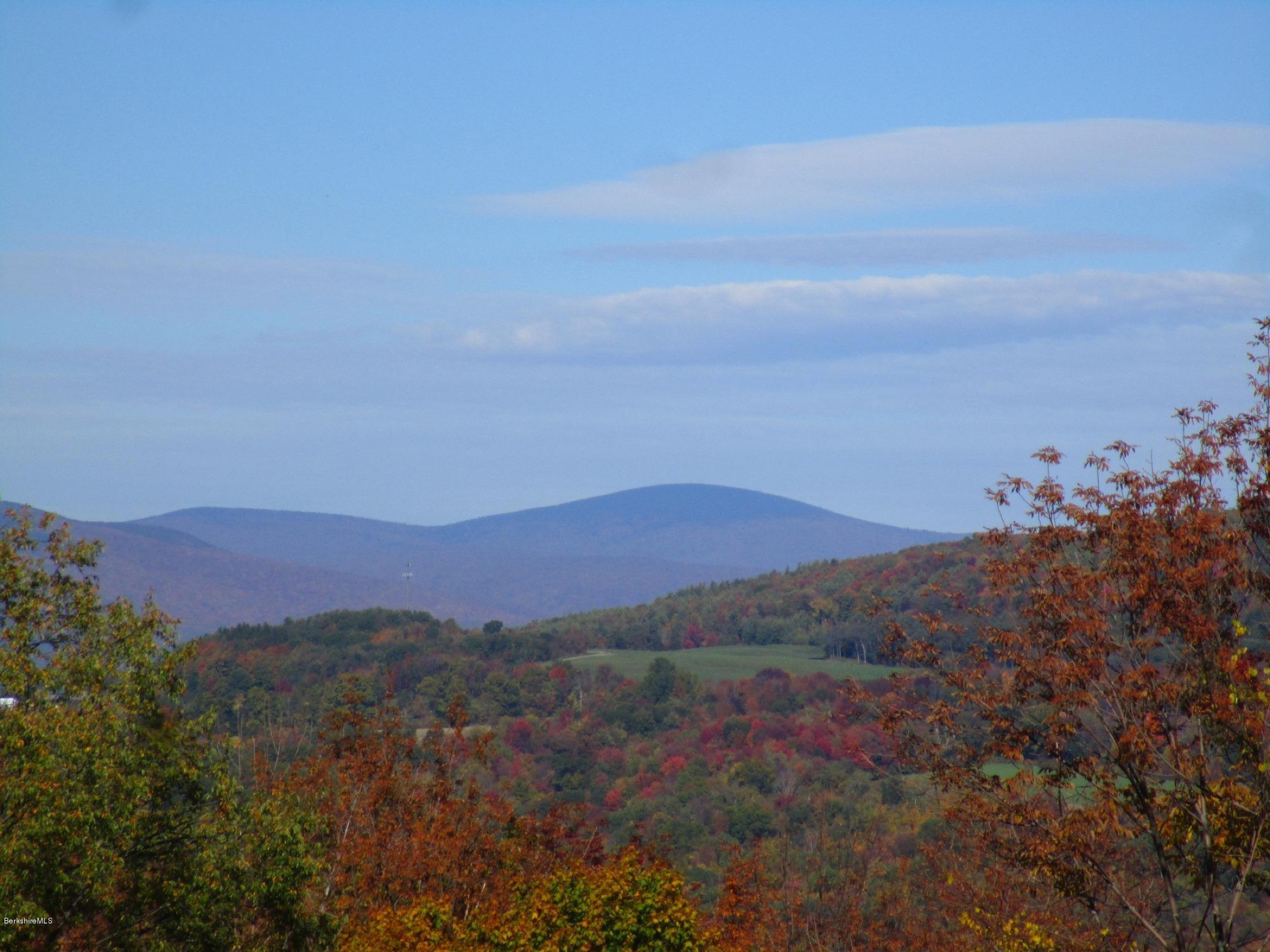 Autumn long-range view from High Meadows Farm across rolling fall-colored hills to the soft blue peaks of the Taconic Ridge
