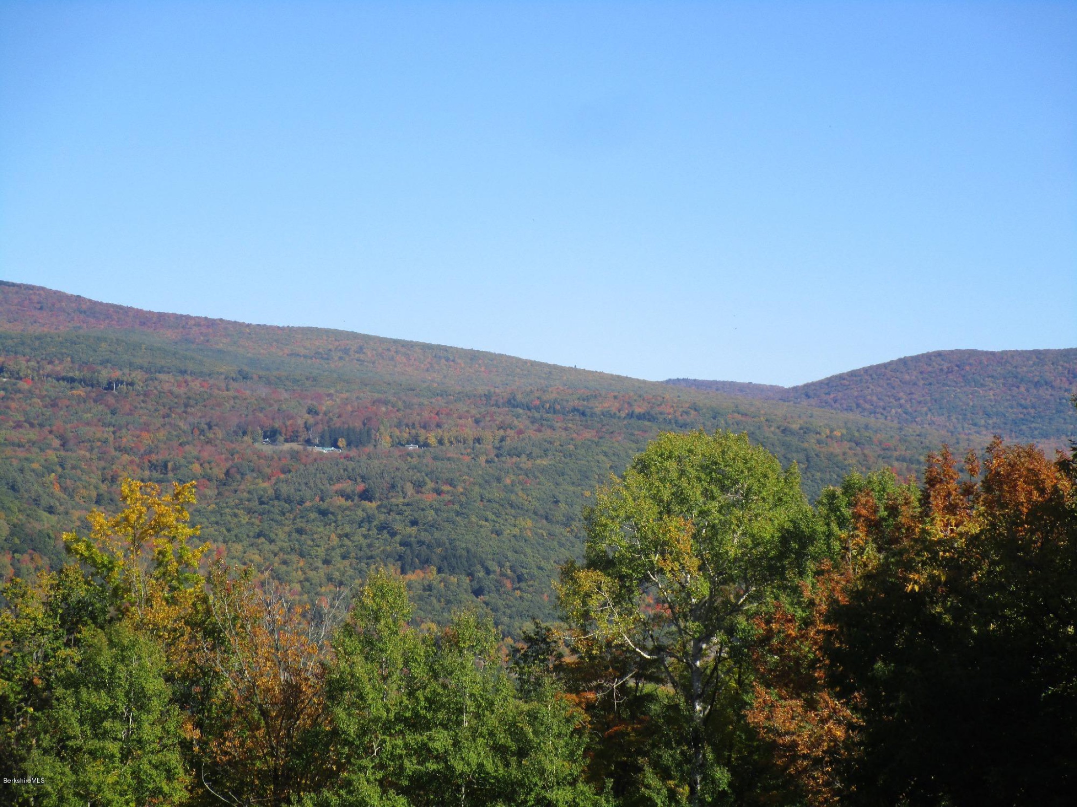A long autumn mountain ridge under a clear blue sky above mixed fall woodland on the High Meadows Farm property
